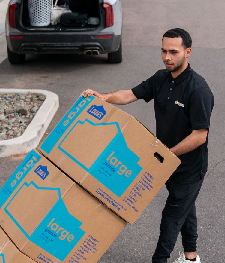 Man carrying large moving boxes outdoors