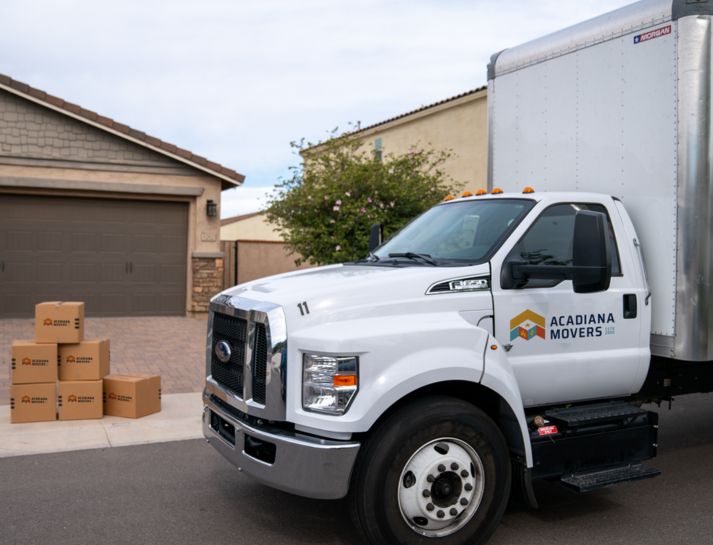 Moving truck parked near house with boxes
